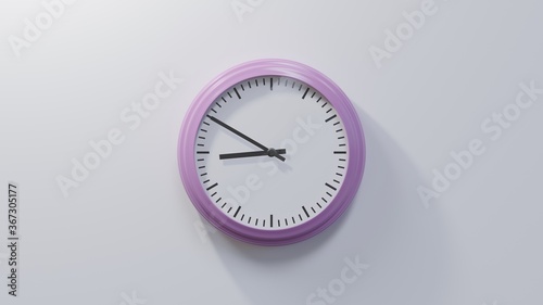 Glossy pink clock on a white wall at ten to nine. Time is 08:50 or 20:50 photo