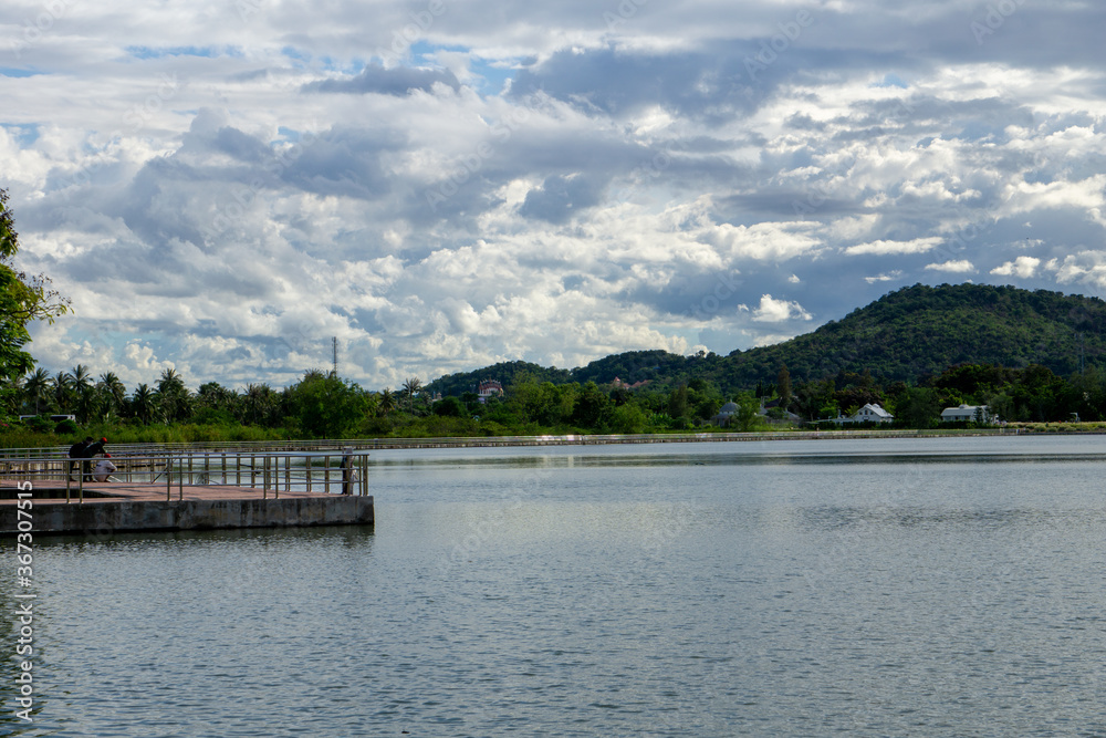 On a cloudy day with a man fishing by the lake