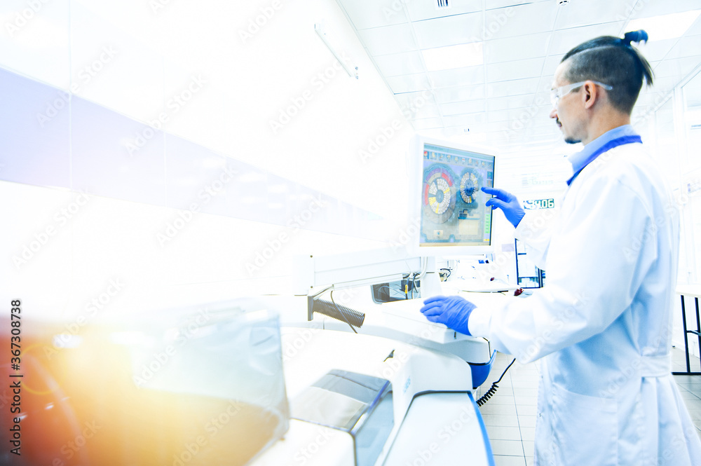 Laboratory assistant in rubber gloves working with a modern immunochemistry analyzer Laboratory assistant in rubber gloves working with a modern immunochemistry analyzer