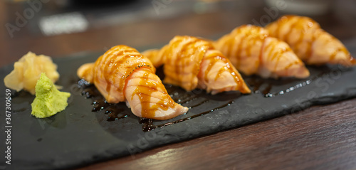 grilled salmon sushi on the black stone plate