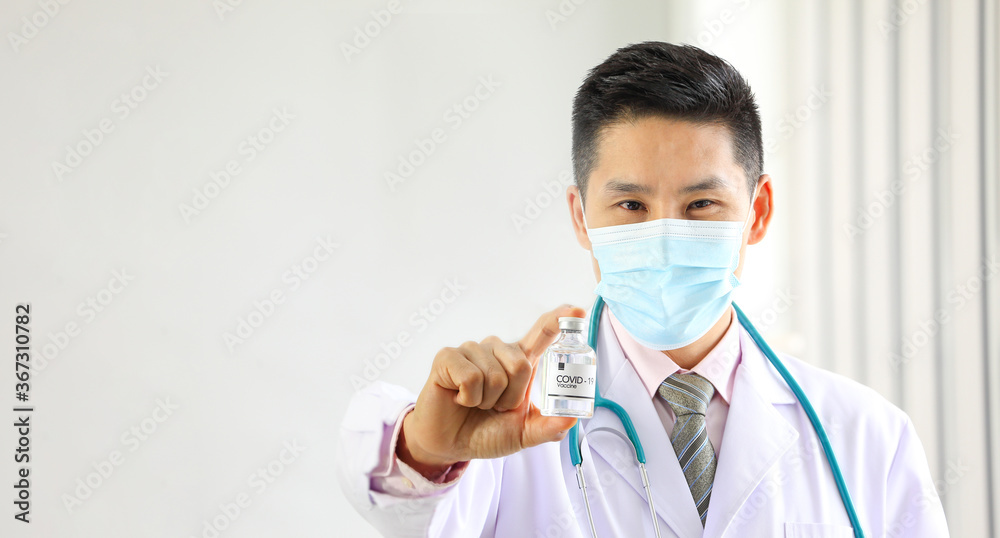 Asian male doctor holding newly discover approved vaccine from laboratory in bottle with copy space Asian male doctor holding newly discover approved vaccine from laboratory in bottle with copy space