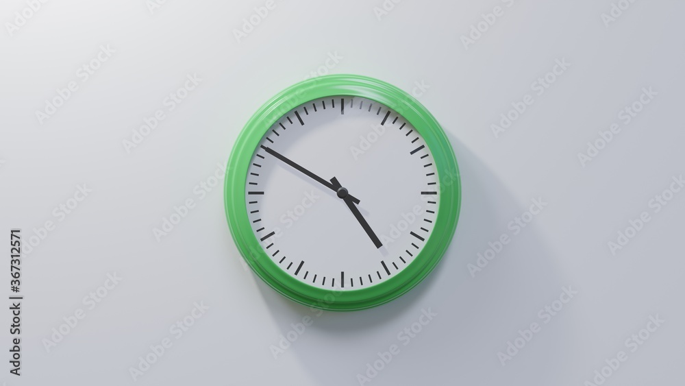 Glossy green clock on a white wall at ten to five. Time is 04:50 or 16:50 Glossy green clock on a white wall at ten to five. Time is 04:50 or 16:50