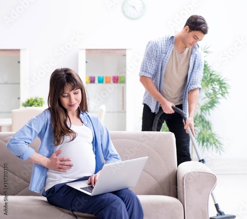 Man helping pregnant wife in cleaning