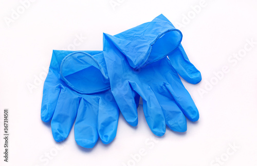 Pair of medical blue latex protective gloves on white background. Protective disposable gloves against the spread of virus, flu, coronavirus (COVID-19), bacterial. Health care and surgical concept.