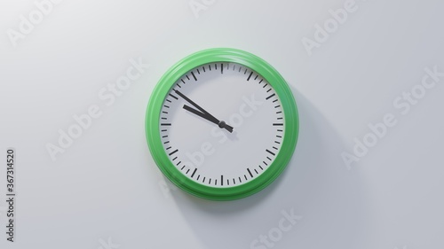 Glossy green clock on a white wall at fifty-one past nine. Time is 09:51 or 21:51
