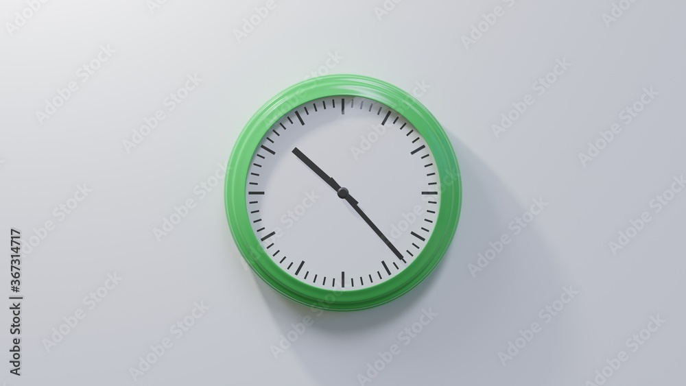 Glossy green clock on a white wall at twenty-three past ten. Time is 10:23 or 22:23 Glossy green clock on a white wall at twenty-three past ten. Time is 10:23 or 22:23
