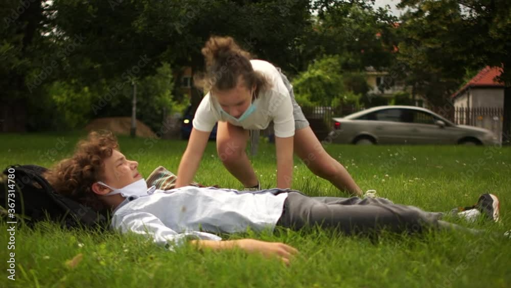 Classmates, boy and girl are resting lying on the grass during school break. Back to school, social distance, contactless greeting Classmates, boy and girl are resting lying on the grass during school break. Back to school, social distance, contactless greeting