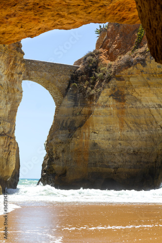 Beautiful rock tunnel and stone footbridge at Estudiantes beach in Lagos, Portugal
