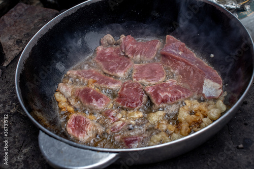 grilled beef steak with rosemary on frying pan. Beef is fried in a frying pan