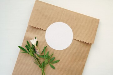Round blank sticker mockup, circle tag mock up on kraft paper gift bag, adhesive thank you card, round product label, pink flowers.
