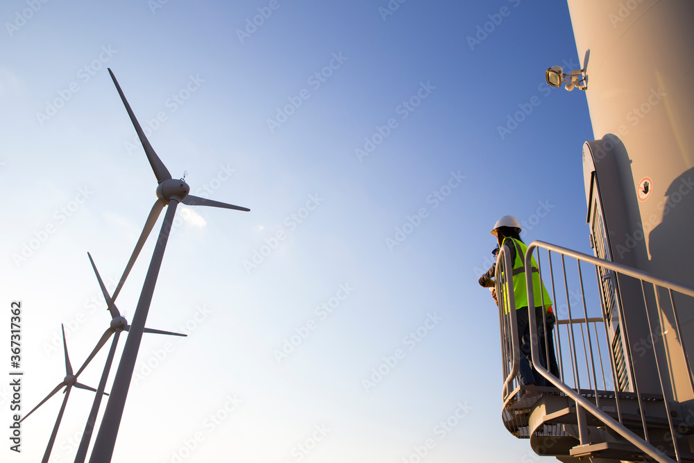 Fototapeta premium Engineers working on wind turbine in wind farm