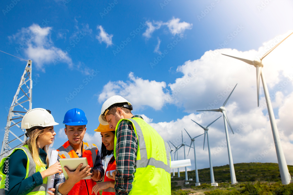 Young engineers and workers having a meeting at wind farm