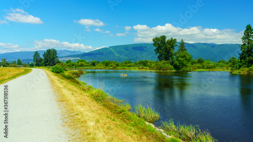 shared bike and walking trail along Alouette river, BC, popular with canoeists and paddleboarders, on a sunny summer day