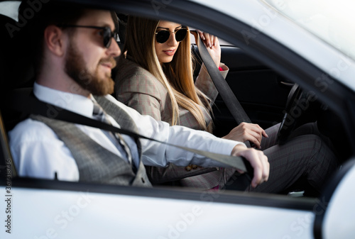 Couple riding in car putting on safety belts 