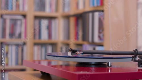 Stopping a blue vinyl lp on a record player and removing stylus photo