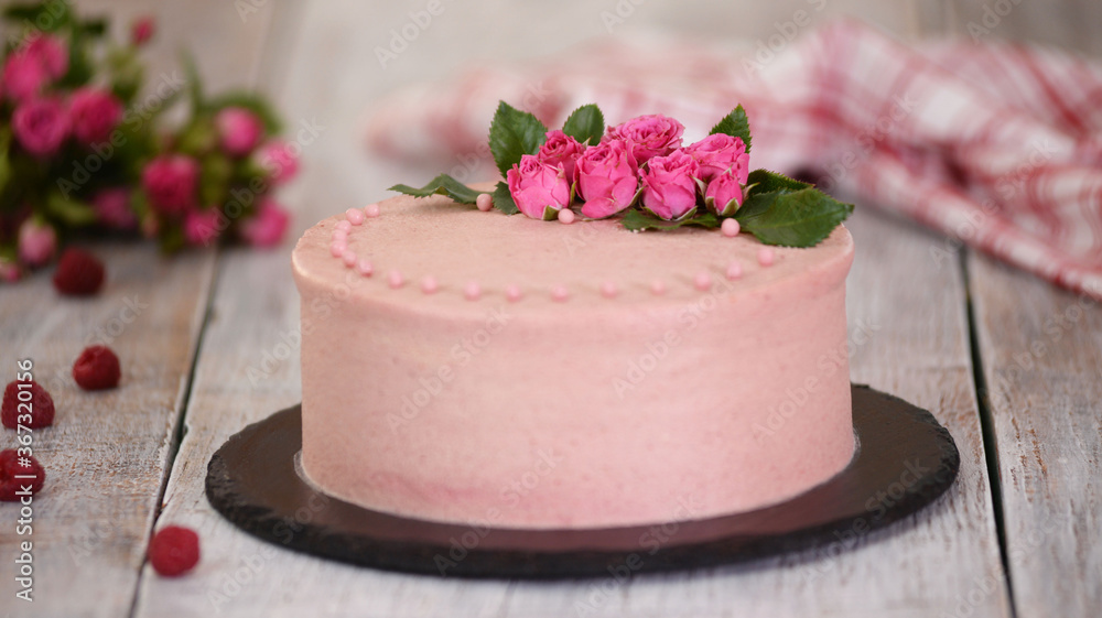 Layers cake with berry filling decorated with fresh roses.