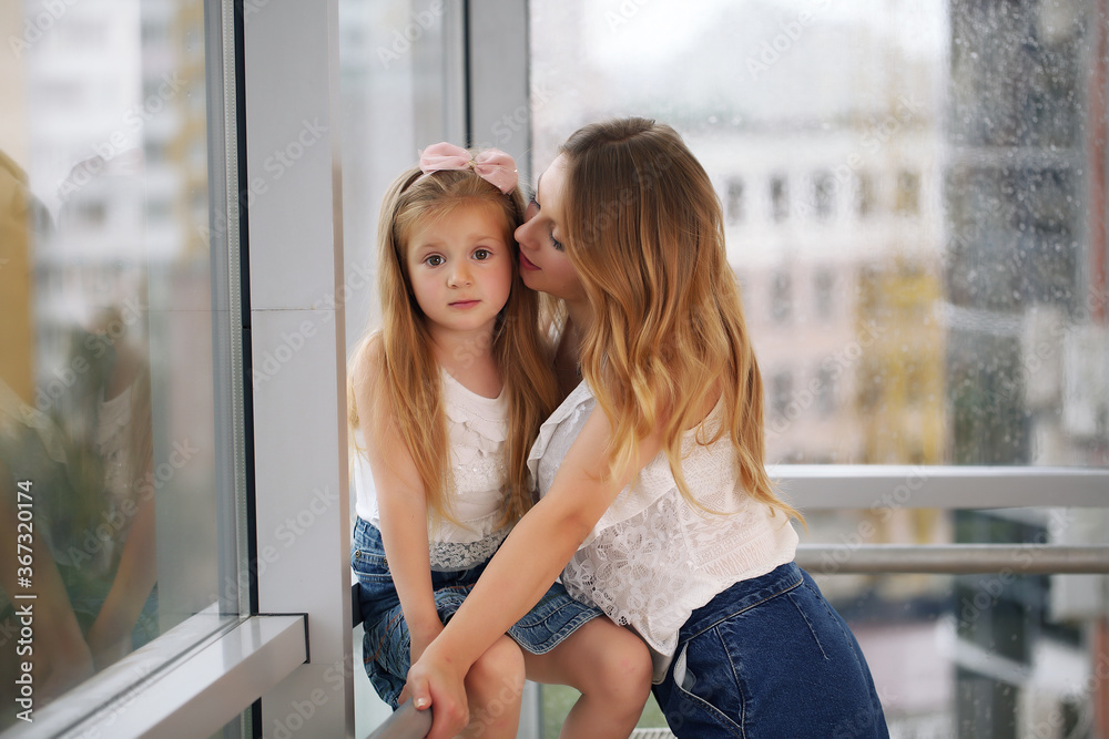 Happy loving family. Mother and her girl play, kiss and hug.