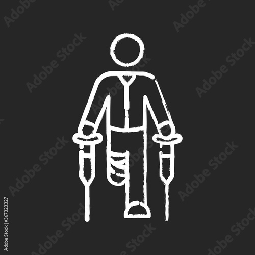 Leg amputee chalk white icon on black background. Disabled man with crutches. Patient with bandaged leg. Recovery from injury. Mobility difficulty. Isolated vector chalkboard illustration