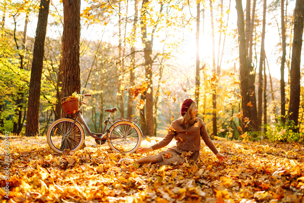 Нappy young woman having fun with leaves in autumn park.  - obrazy, fototapety, plakaty 