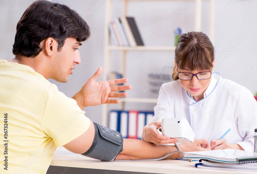 Young doctor checking patients blood pressure Young doctor checking patients blood pressure