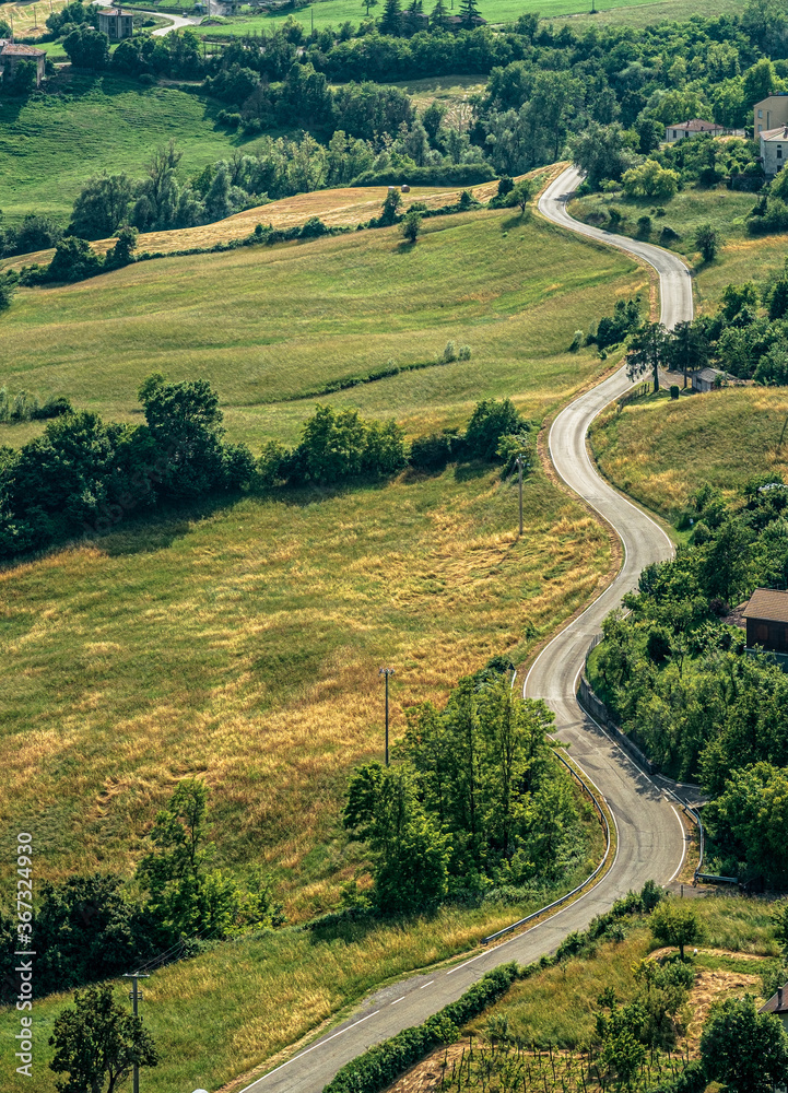 Hilly curvy road without traffic through the hills of the Northern Apennines. Bardi, Parma province, Emilia Romagna, Italy.