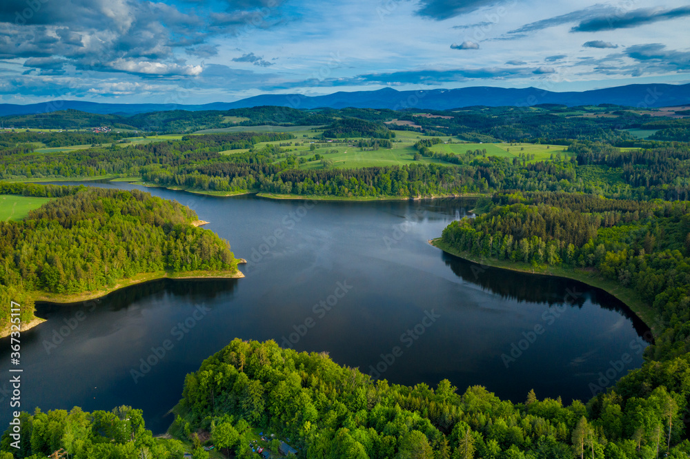 Aerial view of beautiful lake with islands and green forests near Karkonosze Mountains on a sunny summer day in Pilchowice, Lower Silesia, Poland. Drone photography