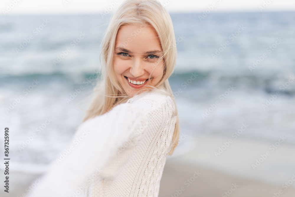 Pretty woman smiling near ocean