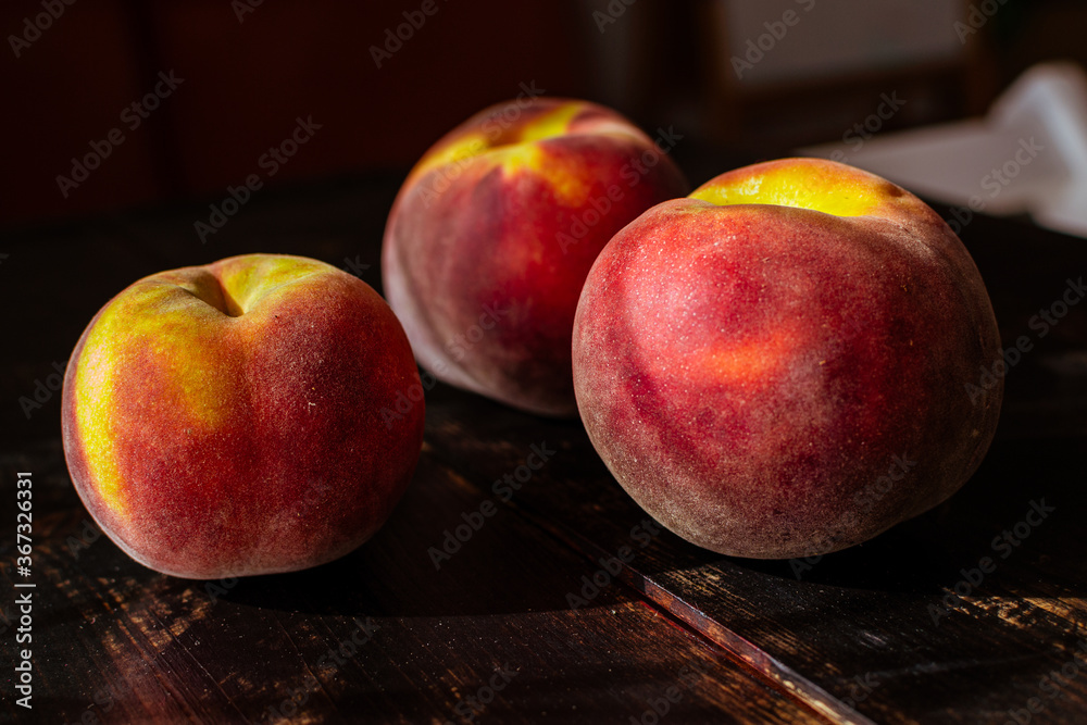 still life with fresh ripe peaches in season on wooden table and kitchen knife still life with fresh ripe peaches in season on wooden table and kitchen knife