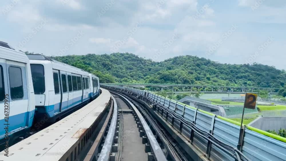 High speed footage of the Taipei metro in Taiwan.  Taipei metro train leaving station with natural view, and a train moving in to the platform.