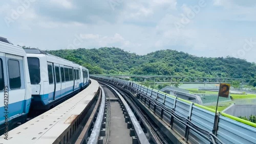 High speed footage of the Taipei metro in Taiwan.  Taipei metro train leaving station with natural view, and a train moving in to the platform.