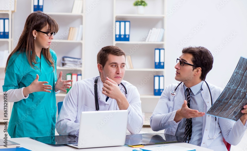 Fototapeta premium Three doctors discussing scan results of x-ray image