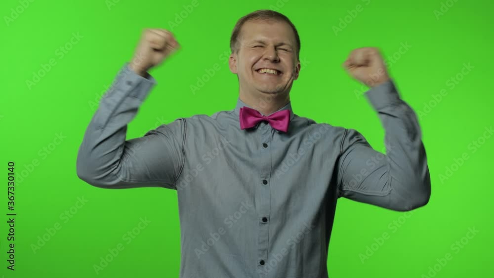 Happy man raising fist in victorious gesture, dancing, celebrating great success, enjoying lucky day Happy man raising fist in victorious gesture, dancing, celebrating great success, enjoying lucky day