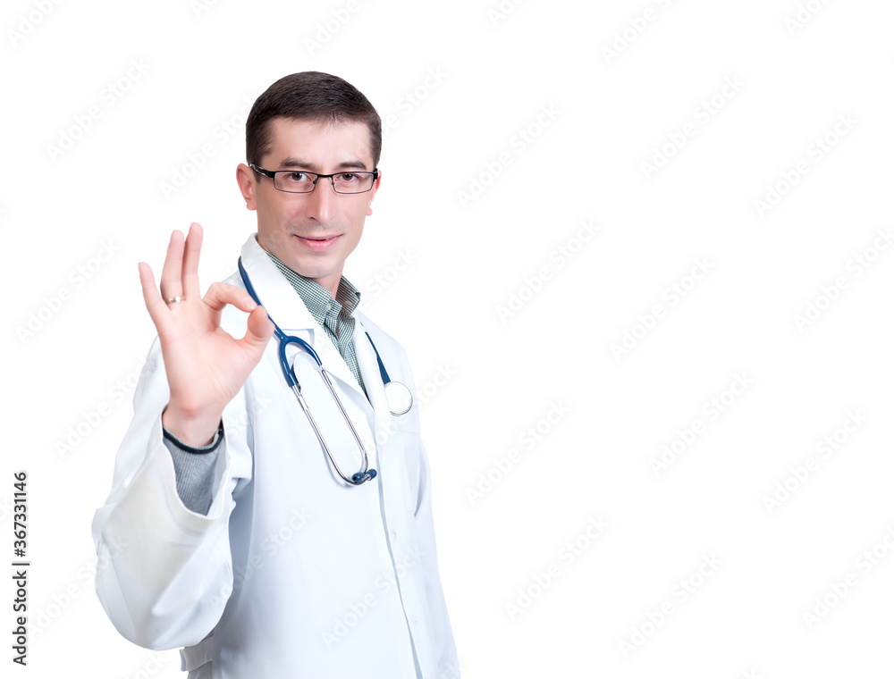 Young man in a white doctor’s coat with a stethoscope posing on a white background in isolation