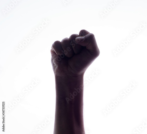 Backlight of a Hand with clenched a fist, isolated on a white background. Struggle and resistance concept. Freedom