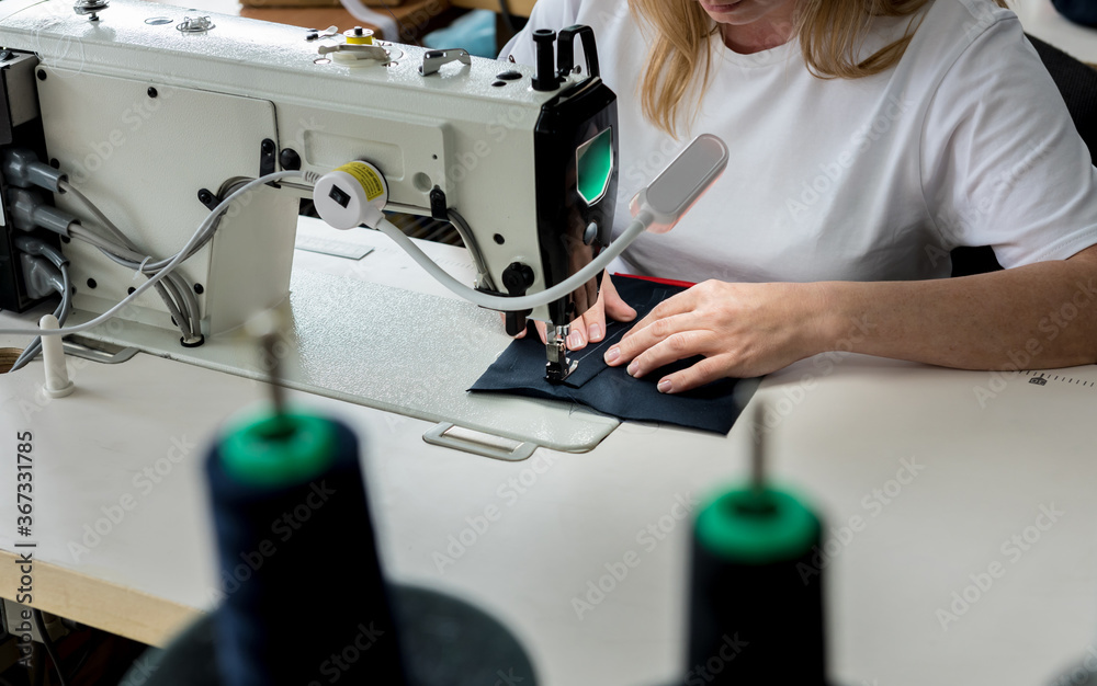 Designer tailor sew the dress. Woman use sewing machine for his work.