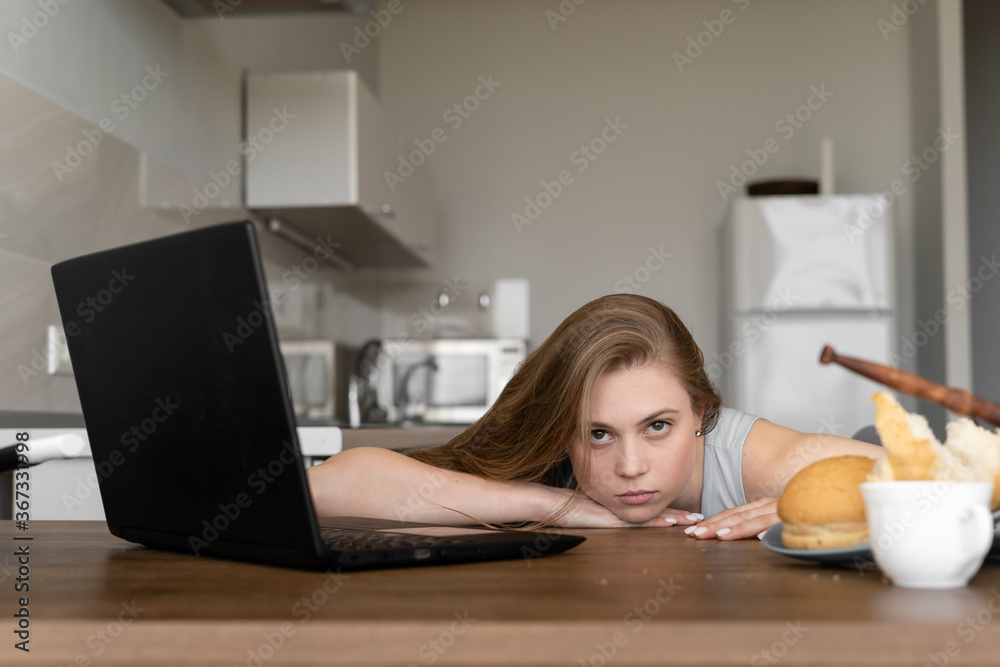 Bored and tired businesswoman working remotely at home in the kitchen. Bored and tired businesswoman working remotely at home in the kitchen.