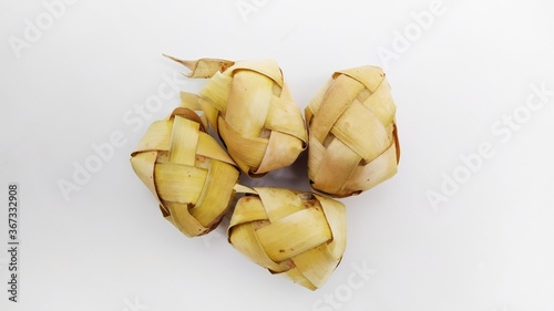 Kupat or ketupat Indonesian traditional food with rice ingredients wrapped with palm leaves isolated on white background photo