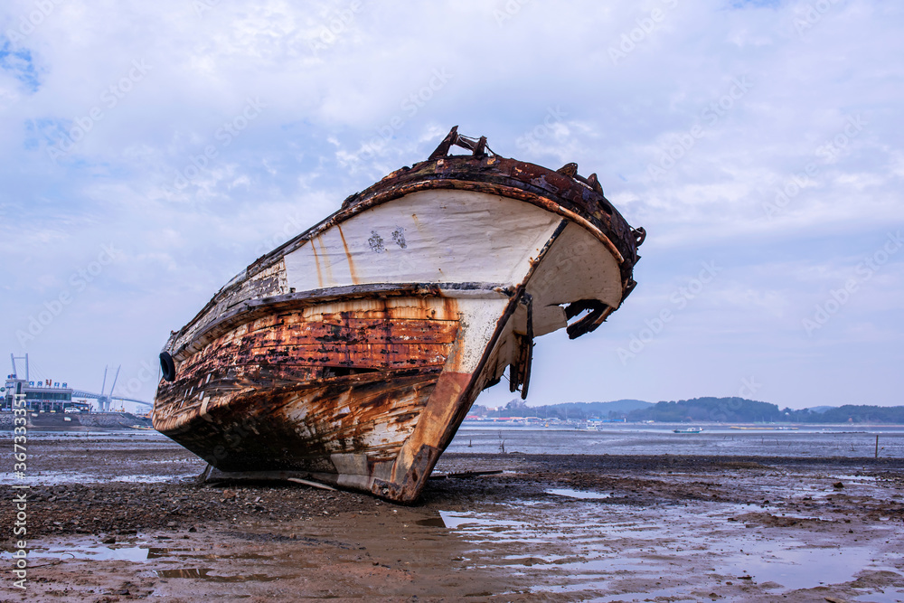  Abandoned and scrapped wooden fishing vessel lying on the beach.
