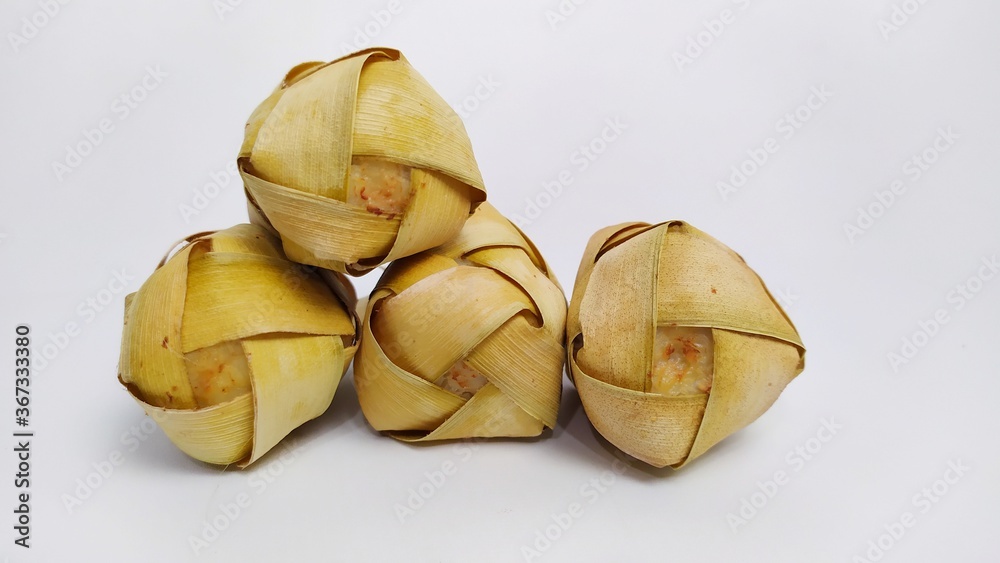 Kupat or ketupat Indonesian traditional food with rice ingredients wrapped with palm leaves isolated on white background Kupat or ketupat Indonesian traditional food with rice ingredients wrapped with palm leaves isolated on white background