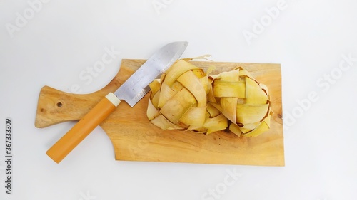 Kupat or ketupat Indonesian traditional food with rice ingredients wrapped with palm leaves isolated on white background photo