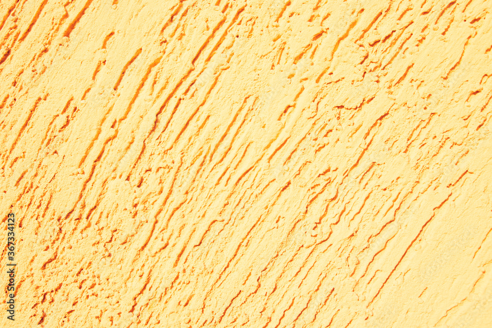 Fototapeta premium Yellow textured plaster. Deep unidirectional strokes on the plaster.