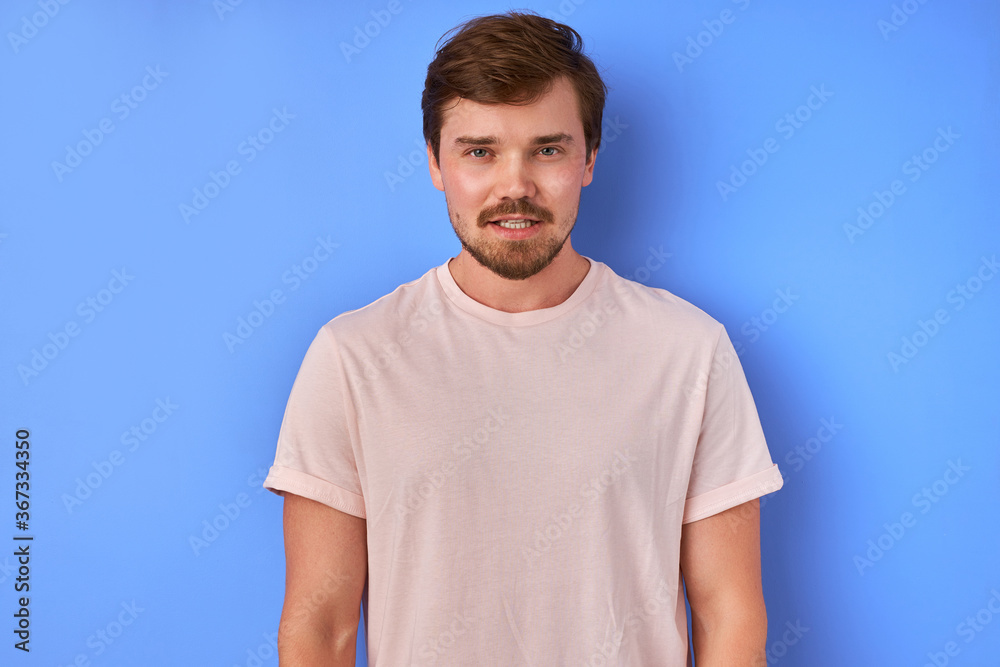 confident calm guy in t-shirt posing at camera isolated in studio, bearded male of caucasian appearance disposes to himself confident calm guy in t-shirt posing at camera isolated in studio, bearded male of caucasian appearance disposes to himself