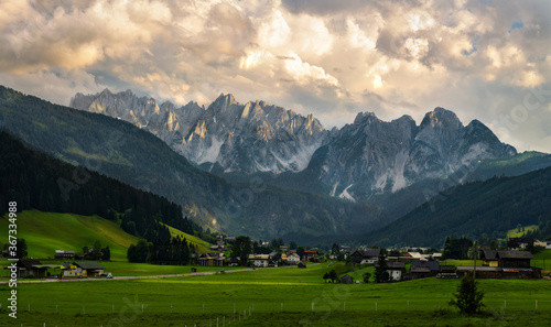 Panoramic view of the mountain chain Gosaukamm within Dachstein mountain ringe and the valley below from Gosau town during the sunset. Austria.