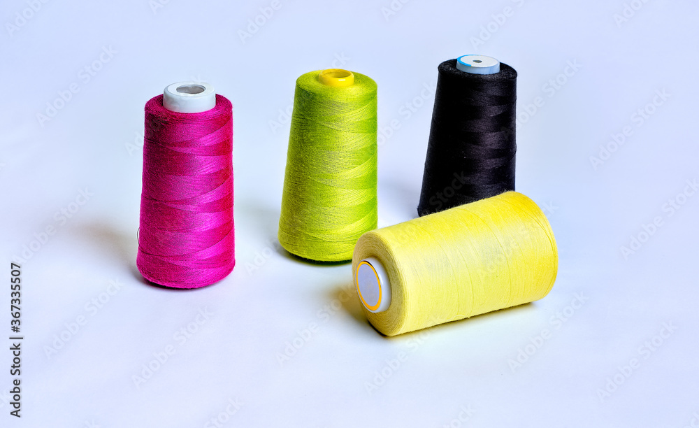 Four sewing thread rolls in different colors isolated on white Four sewing thread rolls in different colors isolated on white