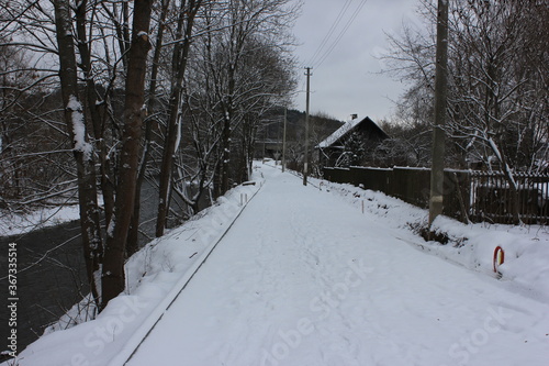 Narrow road by the river covered in snow