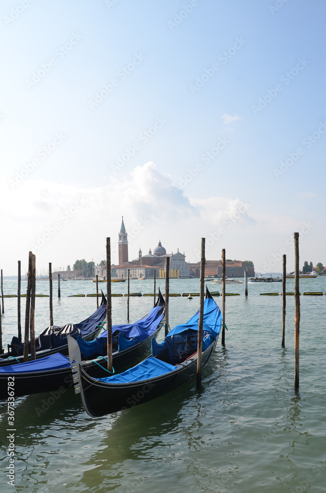 Sunny view on water with gondolas in Venice, Italy
