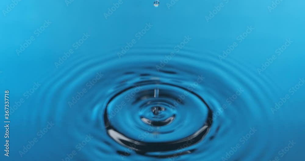 Splash. Round rain drops falling on smooth blue surface of water. Splash. Round rain drops falling on smooth blue surface of water.