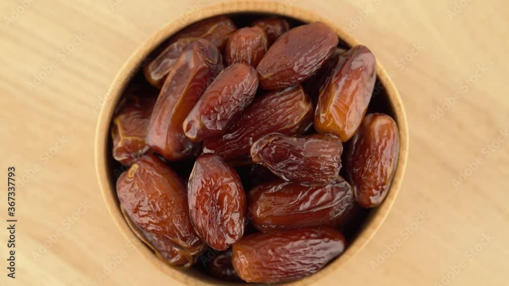 Date fruit in a wooden bowl rotation. Date fruit in a wooden bowl rotation.