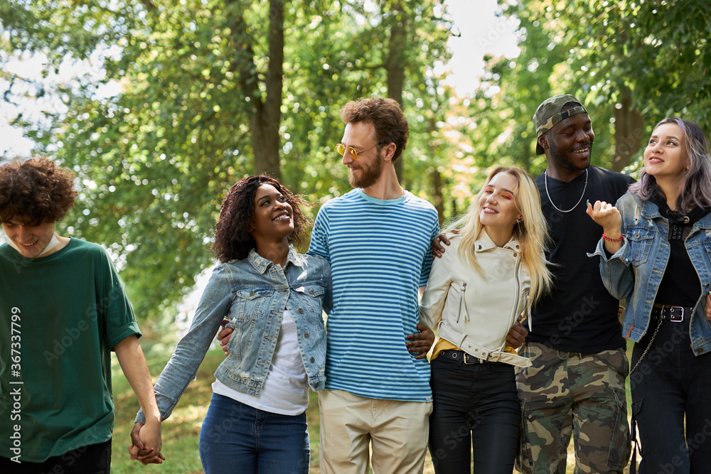 happy diverse african and caucasian people walk together in the park, have conversation and laugh. tolerance, international friendship concept happy diverse african and caucasian people walk together in the park, have conversation and laugh. tolerance, international friendship concept