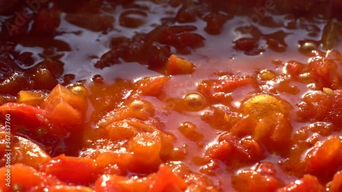 Tomato sauce. Pan Left. Close up..Boiling tomato sauce made from chopped fresh ripe tomatoes..Italian cuisine.